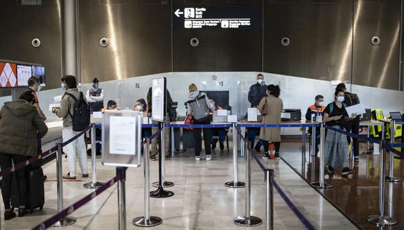 Los pasajeros que llegan de países incluidos en la lista de zonas rojas de coronavirus se registran para las pruebas a su llegada al aeropuerto Roissy Charles de Gaulle en Roissy, cerca de París, el 25 de abril de 2021. (Ian LANGSDON / POOL / AFP).