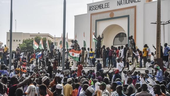 Los partidarios agitan las banderas de Níger mientras se manifiestan en apoyo de la junta de Níger frente a la Asamblea Nacional en Niamey el 30 de julio de 2023. (Foto por AFP)