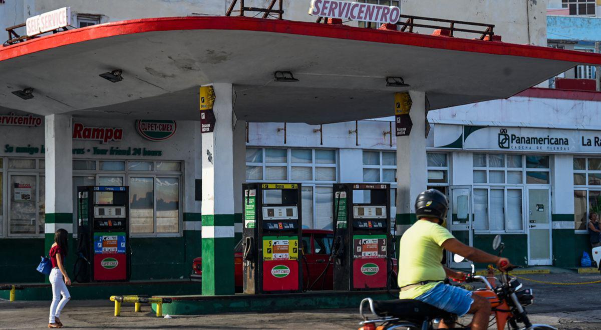 Un hombre en motocicleta pasa frente a una gasolinera vacía en La Habana el 24 de abril de 2023 (Foto: YAMIL LAGE / AFP)