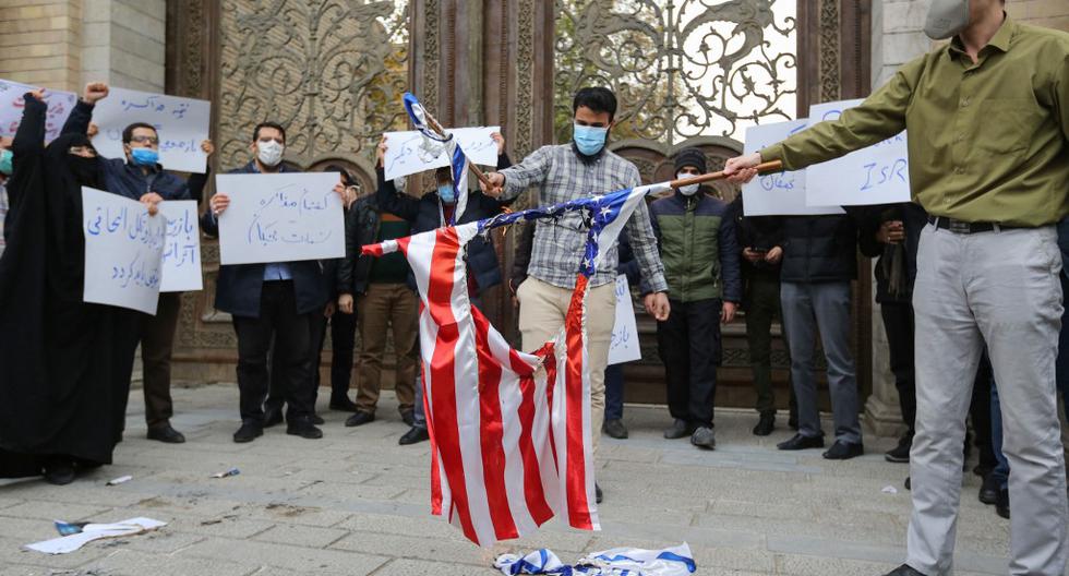 Miembros de la milicia iraní Basij queman banderas de Estados Unidos e Israel frente al Ministerio de Relaciones Exteriores en Teherán, el 28 de noviembre del 2020, en protesta por el asesinato del científico nuclear Mohsen Fakhrizadeh. La justicia iraní determinó este jueves que Estados Unidos e Israel son los responsables de los asesinatos de un grupo de científicos vinculados al programa nuclear de la república islámica entre el 2010 y el 2020.