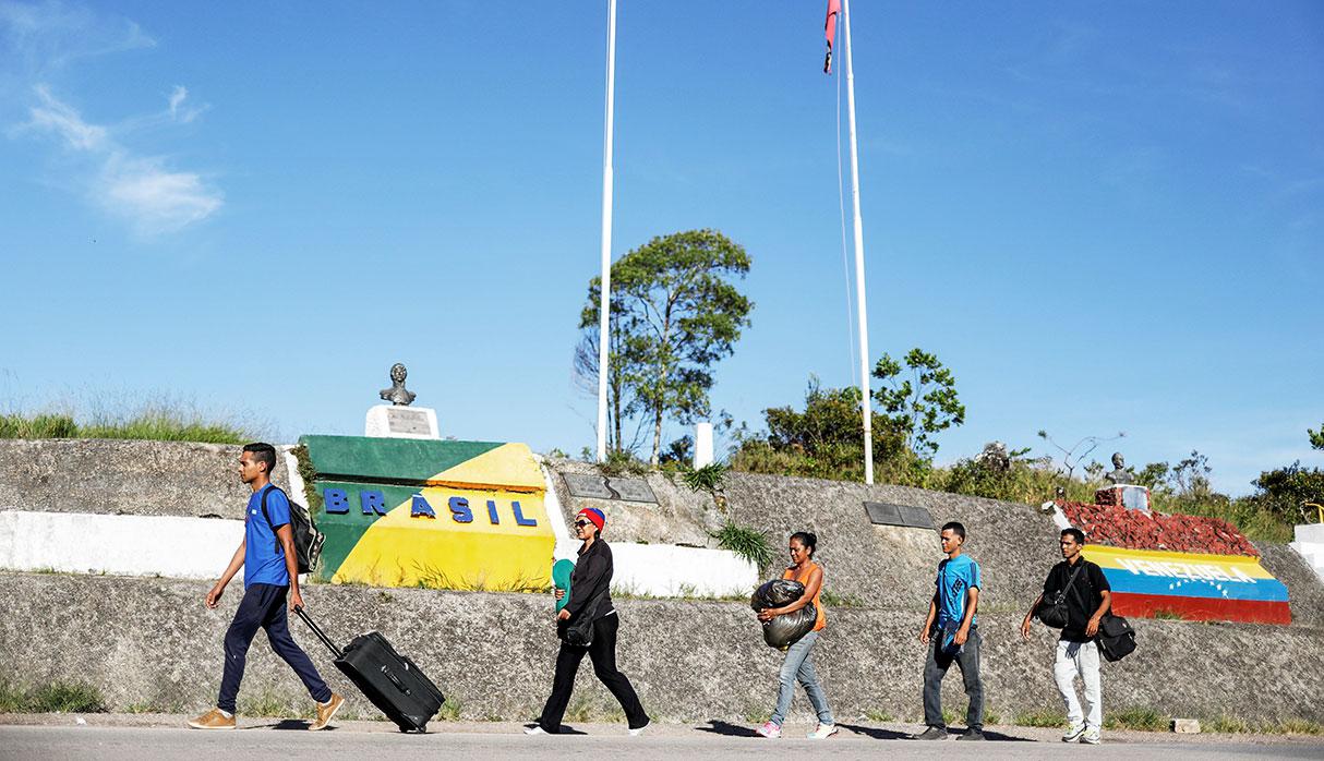 Venezuelans walk across the border from Venezuela into the Brazilian city of Pacaraima, Roraima state, Brazil November 16, 2017. REUTERS/Nacho Doce    SEARCH "VENEZUELAN MIGRANTS" FOR THIS STORY. SEARCH "WIDER IMAGE" FOR ALL STORIES.