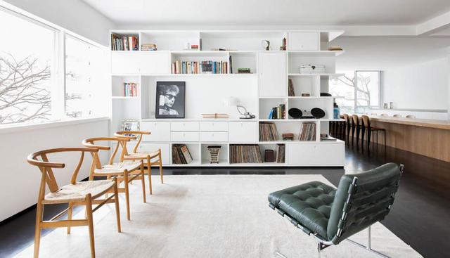 Los ambientes de la casa están unificados por las paredes blancas y el pisode madera negra. Se lucen tres sillas Wishbone y una Barcelona. (Foto: Ricardo Bassetti)