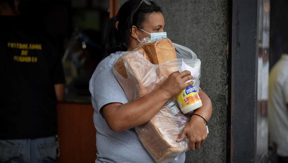 Una mujer carga sus compras mientras sale de un supermercado, el 14 de abril de 2021, en Caracas, Venezuela. (Foto: EFE/RAYNER PEÑA R.).