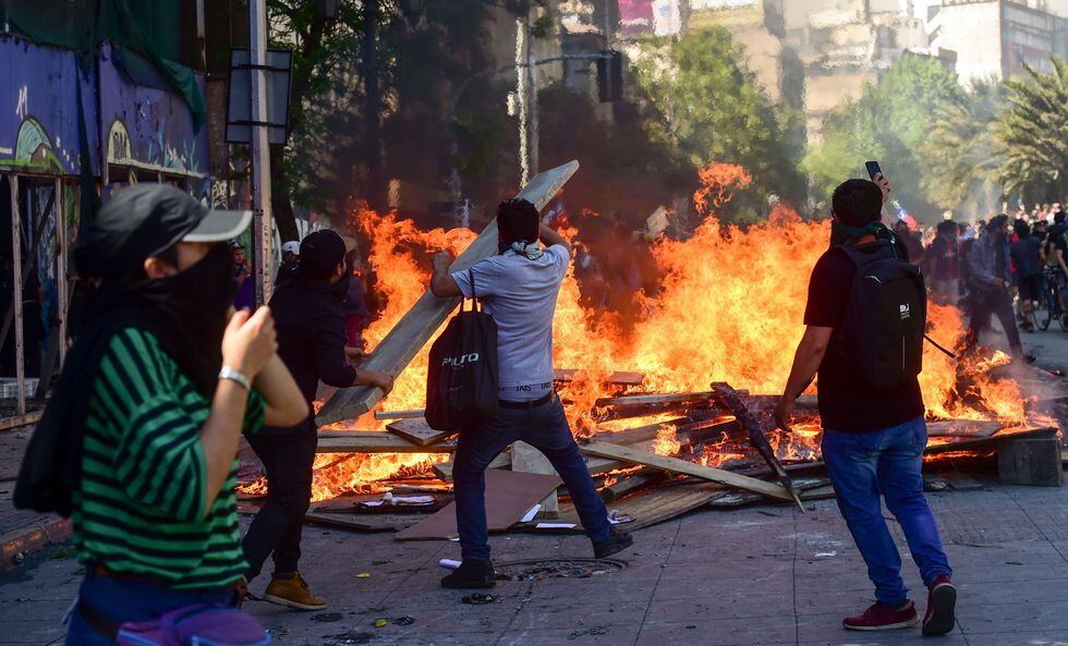 Un grupo de manifestantes prende fuego a una barricada durante una protesta en Santiago. (AFP / Martin BERNETTI).