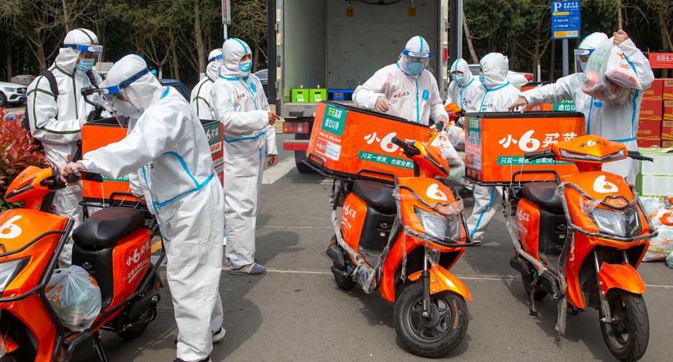 Los repartidores con equipo de protección personal (EPP) se preparan para entregar alimentos a los habitantes de Ningbo, en la provincia oriental china de Zhejiang, que están en confinamiento por coronavirus. (STR / AFP).