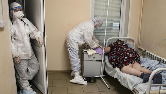 Un miembro del personal médico con un traje protector trata a una paciente de coronavirus COVID-19 en un hospital de Nizhny Novgorod, en Rusia, el miércoles 20 de octubre de 2021. (Foto AP / Roman Yarovitcyn).
