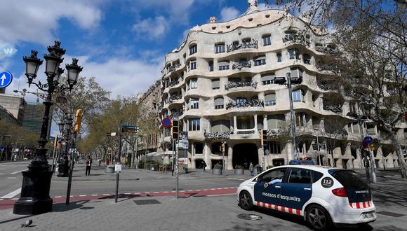 Un auto de la policía de Catauña delante de la Pedrera de Gaudí. Las calles se muestran vacías por el confinamiento del coronavirus. Foto: AFP