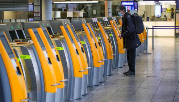 Un pasajero usa una máquina de auto check-in en el Aeropuerto Internacional de Frankfurt, en el oeste de Alemania, el 21 de diciembre de 2020, en medio de la pandemia del nuevo coronavirus. (Armando BABANI / AFP).