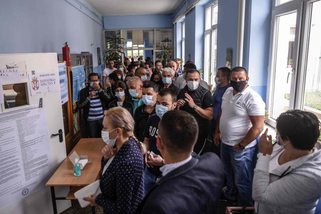 Los serbios de Kosovo usan máscaras faciales mientras se preparan para emitir sus votos en un colegio electoral en Gracanica el 21 de junio de 2020, durante una elección para un nuevo parlamento en las primeras elecciones nacionales de Europa desde la pandemia de coronavirus. (AFP/ARMEND NIMANI).