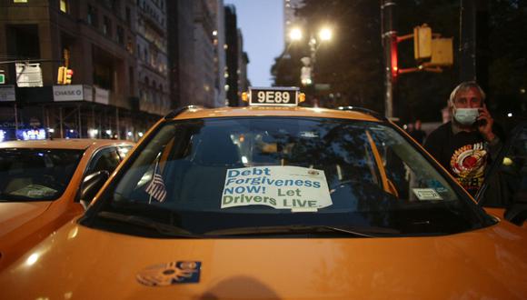 Los carteles se muestran en las ventanas de un taxi amarillo en Nueva York. (Foto: Kena Betancur / AFP).