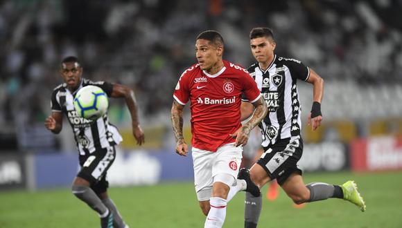 Paolo Guerrero yendo por el balón mientras es perseguido por dos oponentes. (Foto: AFP)