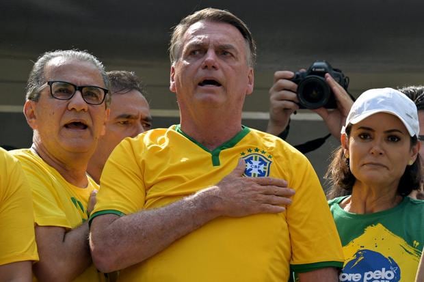 El ex presidente brasileño Jair Bolsonaro canta el himno nacional junto a su esposa Michelle Bolsonaro y el pastor Silas Malafaia durante una manifestación en Sao Paulo, el 25 de febrero de 2024. (Foto de NELSON ALMEIDA / AFP).