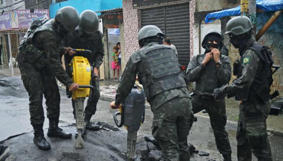 Militares removiendo un bloqueo de calle en una favela de Río de Janeiro, uno de los puntos más violentos de Brasil. (AFP)