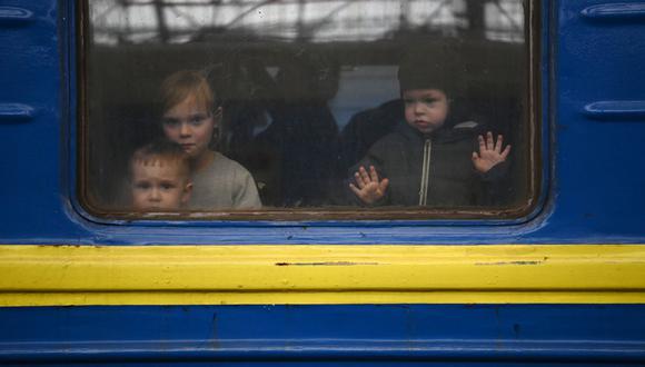 Unos niños miran desde la ventana de un vagón mientras un tren se prepara para partir de una estación en Lviv, en el oeste de Ucrania, en ruta a la ciudad de Uzhhorod, cerca de la frontera con Eslovaquia, el 3 de marzo de 2022. (Foto: Daniel LEAL / AFP)