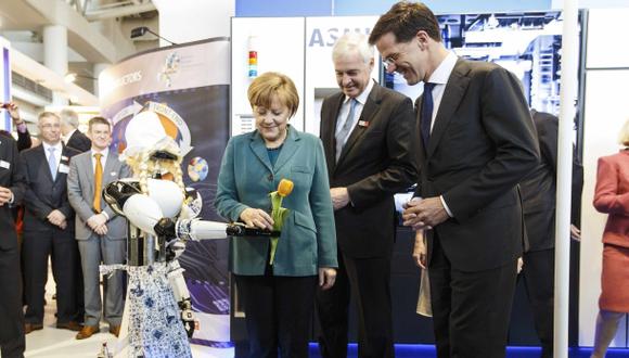 Una robot le ofrece un tulipán a la canciller alemana Angela Merkel. (Foto: Reuters)