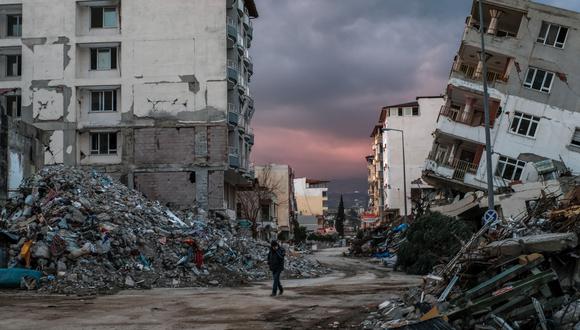 Imagen de archivo / Un hombre camina entre edificios derrumbados, un día después de que un terremoto de magnitud 6,4 azotara la región, en la ciudad costera de Samandag el 21 de febrero de 2023. (Foto: BULENT KILIC / AFP)