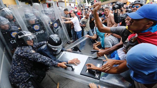 Manifestantes de la oposición se enfrentan con la policía que bloquea su marcha en Venezuela. (Foto: AFP).