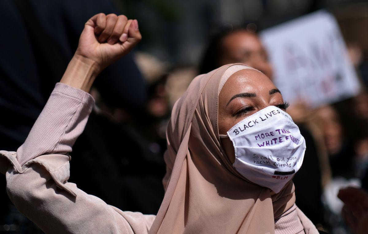 Una mujer con una máscara facial levanta el puño durante una protesta contra la muerte del hombre afroamericano George Floyd, en la plaza Hermannplatz en el distrito de Neukoelln, Berlín, Alemania. (REUTERS / Christian Mang)