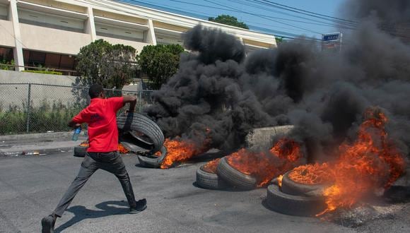 Un manifestante quema neumáticos durante una manifestación tras la dimisión de su primer ministro Ariel Henry, en Puerto Príncipe, Haití, el 12 de marzo de 2024. (Foto de Clarens SIFFROY / AFP)