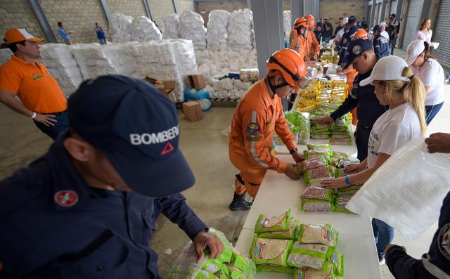 Más de 100 personas organizan en Cúcuta toneladas de paquetes de alimentos que servirán para ayudar, durante 10 días, a miles de familias venezolanas. (AFP)