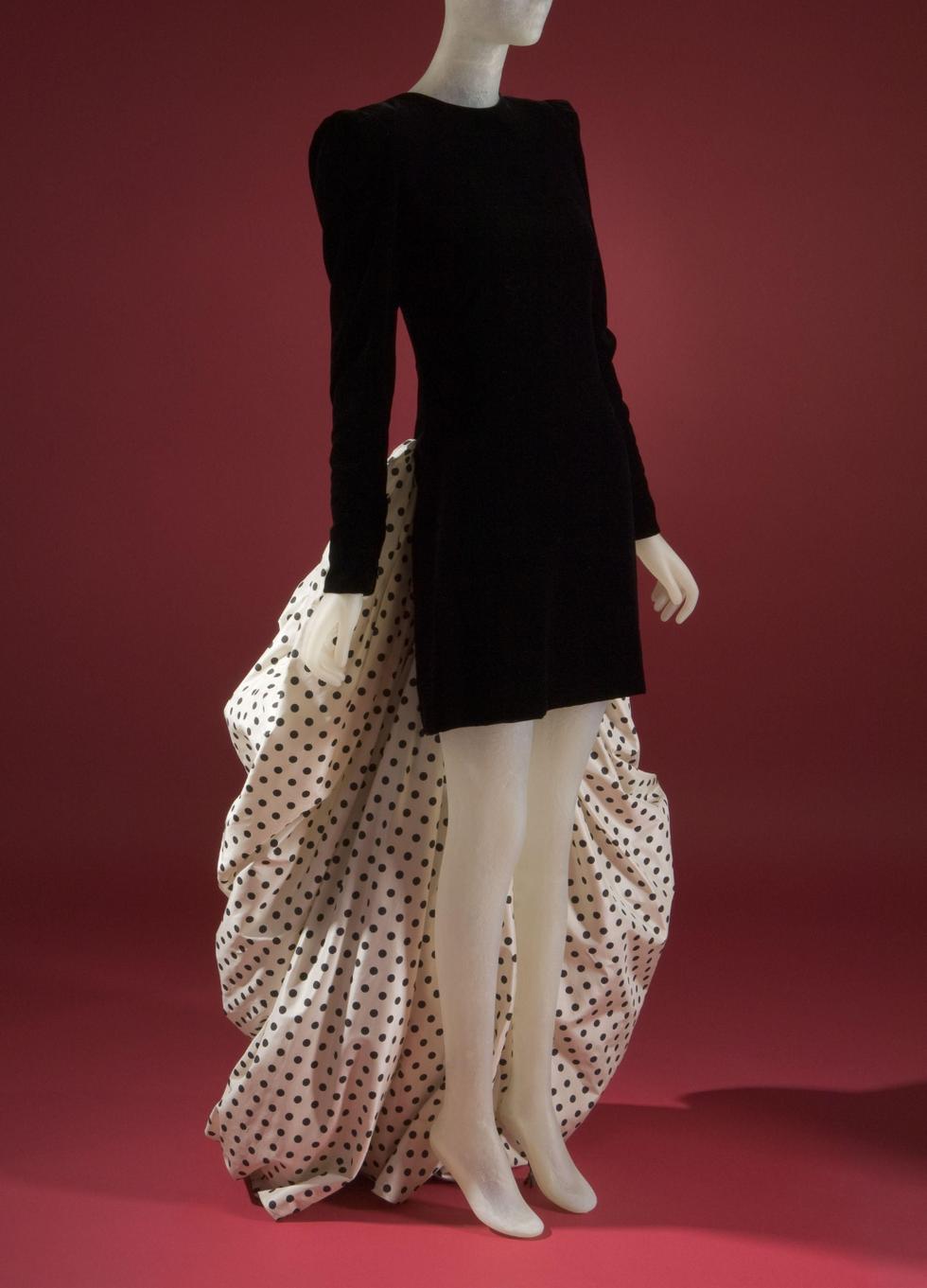 Para su colección de otoño de 1988, Carolina diseñó un vestido de cocktail que quedó grabado para siempre en la memoria de la moda. Este icónico diseñó unió un minivestido negro de corte minimalista con una llamativa y voluminosa cola de lunares negros sobre tela blanca. (Foto: FIT)