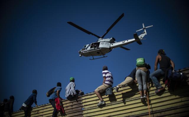 Cientos de migrantes intentan saltar la valla de México a Estados Unidos. (AFP).
