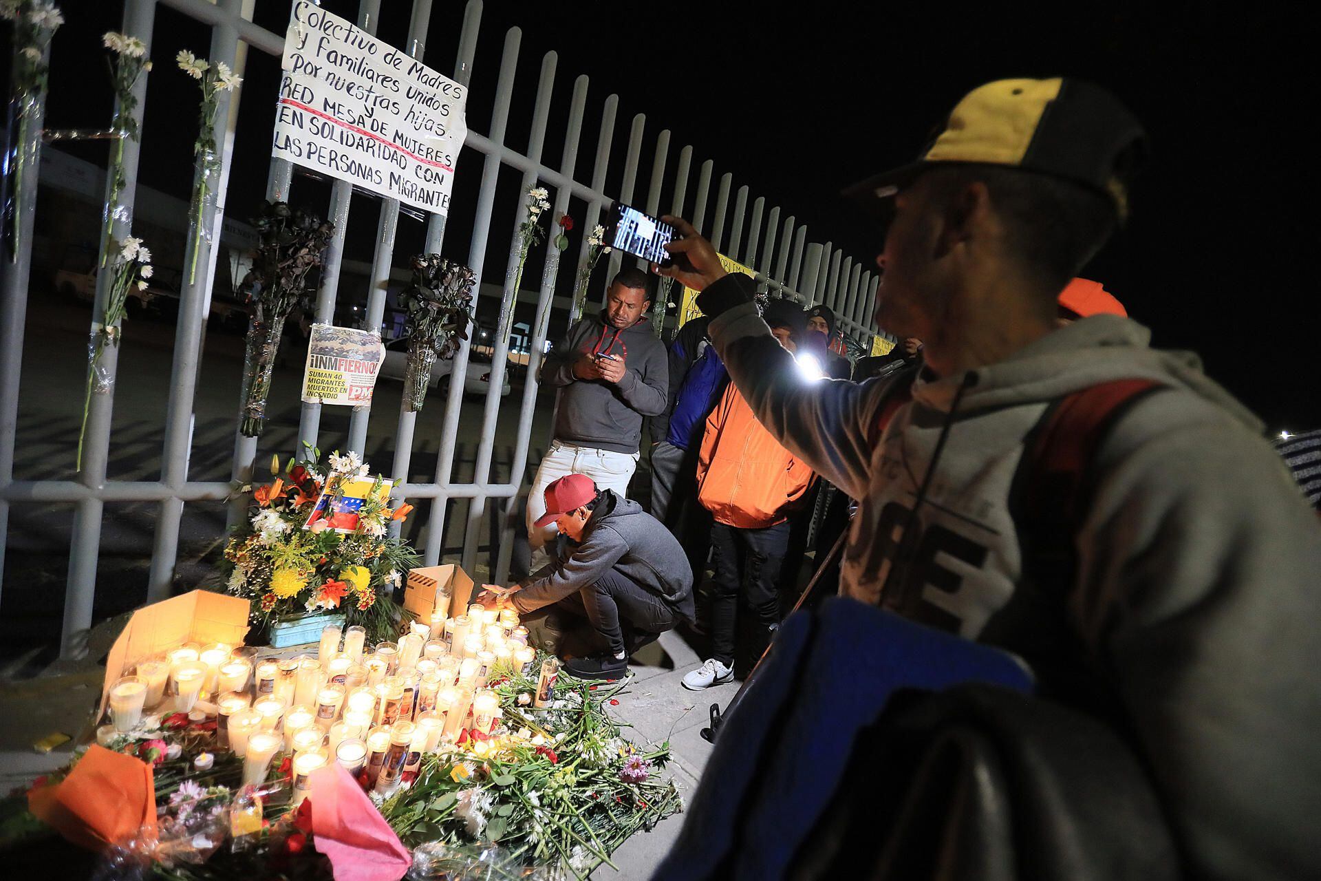 A group of migrants and relatives of people killed by a fire hold a vigil in memory of the 38 victims, in front of the National Institute of Migration (INM), today in Ciudad Juárez, in the state of Chihuahua (Mexico).  Hundreds of migrants demonstrated and demanded justice on Tuesday night outside the National Migration Institute (INM) in Mexico's Ciudad Juárez, Chihuahua, where 38 migrants died in a fire at a immigration station on Monday night.  (Photo: EFE/Luis Torres)