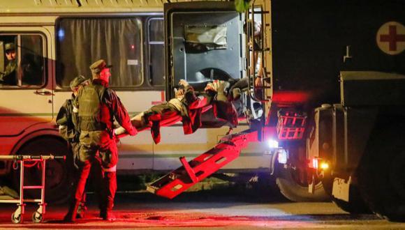 Un miembro del servicio herido de las fuerzas ucranianas de la planta siderúrgica Azovstal sitiada en Mariupol es transportado fuera de un autobús en una camilla escoltado por el ejército prorruso en el curso del conflicto entre Ucrania y Rusia a su llegada a Novoazovsk, Ucrania.