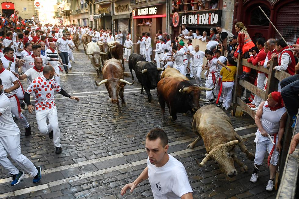Los imponentes toros bravos de lidia, de más de media tonelada, volvieron este jueves a recorrer las calles de la ciudad española de Pamplona como parte de los festejos de San Fermín, enviando a cinco personas al hospital. (Texto: AFP / Foto: MIGUEL RIOPA / AFP)