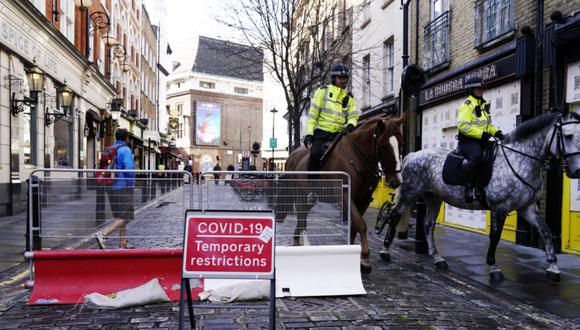 Los caballos de la policía pasan un cartel de COVID-19 en el centro de Londres, Gran Bretaña. (Foto: EFE/EPA/WILL OLIVER).