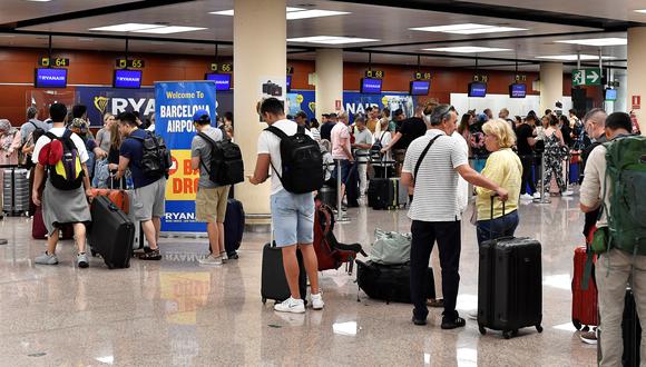 Pasajeros hacen cola en los mostradores de facturación de Ryanair en la Terminal 2 del aeropuerto de El Prat en Barcelona el 1 de julio de 2022. (Foto: Pau BARRENA / AFP)