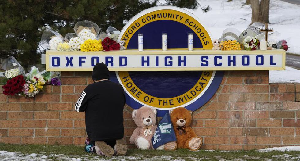 Una persona se arrodilla para orar junto al letrero del Oxford High School en Oxford, Michigan, el miércoles 1 de diciembre de 2021, un día después del tiroteo que dejó 4 muertos. (Foto AP / Paul Sancya).