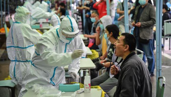 Trabajadores médicos toman muestras para determinar nuevos casos de coronavirus en Wuhan. Foto: China OUT
 / AFP / STR