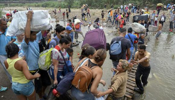 La gente cruza de Cucuta en Colombia de regreso a San Antonio del Táchira en Venezuela después de comprar bienes para revender, a través de puentes improvisados en las "trochas". (Foto: AFP)