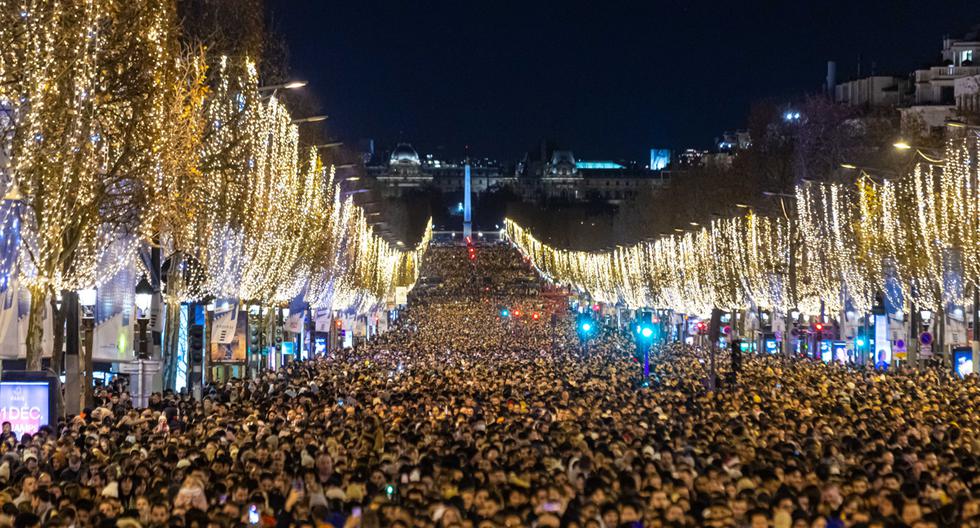 Personas se preparan para celebrar el año nuevo 2023 y ver un espectáculo de luces y fuegos artificiales en el Arco del Triunfo en la avenida de los Campos Elíseos en París, Francia, el 31 de diciembre de 2022. (Foto de EFE/EPA/CHRISTOPHE PETIT TESSON)