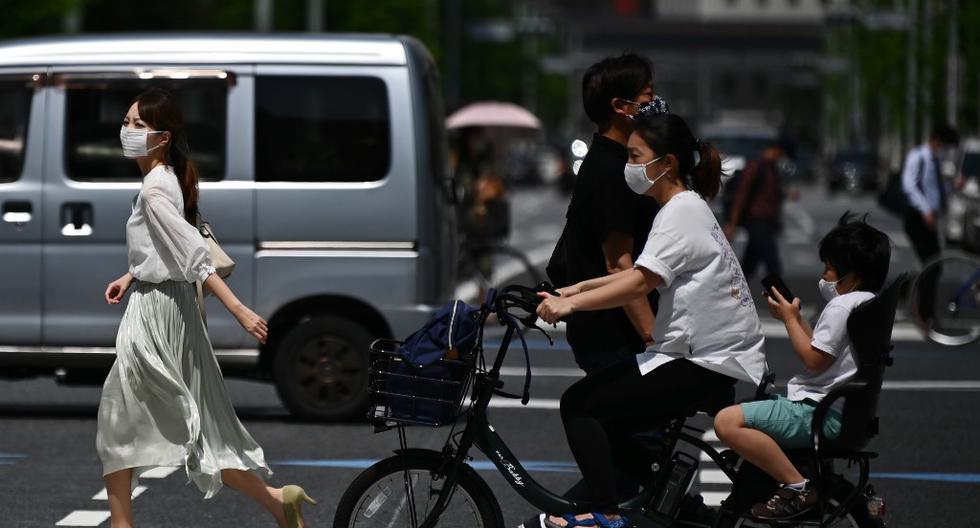 Las personas usan máscaras faciales en medio del brote de COVID-19 en Tokio, Japón. (Foto de Charly TRIBALLEAU / AFP)