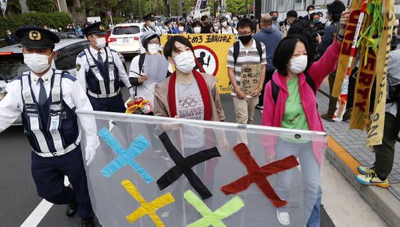 En Japón, manifestantes en contra de la organización de Tokio 2020 cargan un cartel en alusión al logo de las Olimpiadas. (REUTERS).