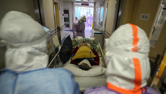 Esta foto tomada el 28 de febrero de 2020 muestra a unos médicos llevando a un paciente infectado por el coronavirus en Wuhan, localidad donde empezó todo. Foto: AFP