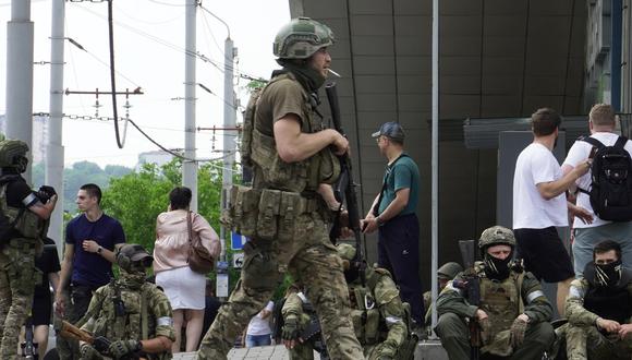Los miembros del grupo Wagner se sientan en la acera mientras patrullan el centro de Rostov-on-Don, el 24 de junio de 2023. (Foto de STRINGER / AFP)