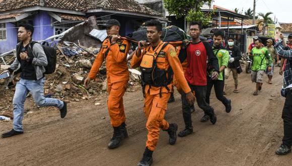 Miembros de un equipo indonesio de búsqueda y rescate llevan el cuerpo de una víctima recuperada de una casa colapsada en una bolsa de cadáveres en Rajabasa, en la provincia de Lampung. (Foto: AFP)