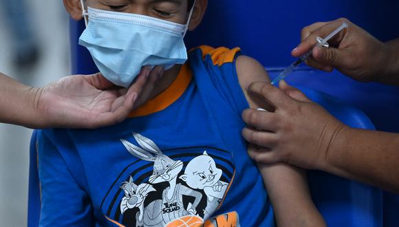En esta imagen de archivo tomada el 22 de septiembre de 2021, un niño recibe una dosis de la vacuna Sinopharm en el principal centro de vacunación de El Salvador.  (Foto: MARVIN RECINOS / AFP)