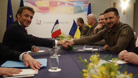 El presidente de Ucrania, Volodymyr Zelensky (derecha), le da la mano al presidente de Francia, Emmanuel Macron, durante su reunión bilateral al margen de la Cumbre de Líderes del G7 en Hiroshima el 20 de mayo de 2023. (Foto de Ludovic MARIN / AFP)
