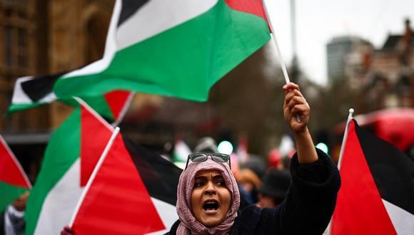 Una manifestante ondea la bandera palestina mientras canta consignas durante una protesta en la Plaza del Parlamento en Londres el 21 de febrero de 2024. (Foto de HENRY NICHOLLS / AFP)