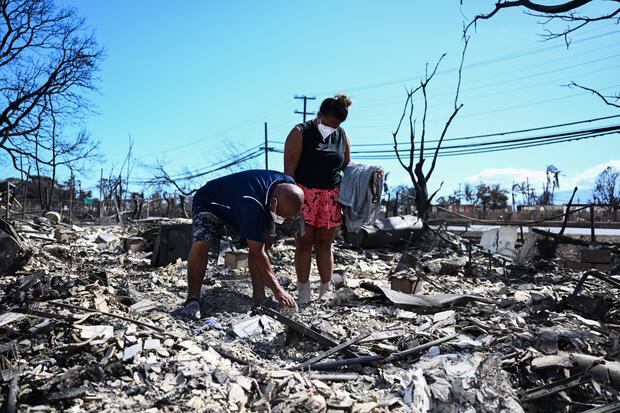 Davelyn Severson and Hanno Kaner search through the ashes of their family home after a wildfire in Lahaina, West Maui, on Aug. 11, 2023.  (Photo by Patrick D. Fallon/AFP)