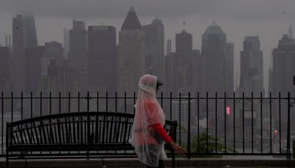 Una mujer camina mientras se ve el horizonte de Nueva York antes de la llegada de la tormenta tropical Henri. (KENA BETANCUR / AFP).
