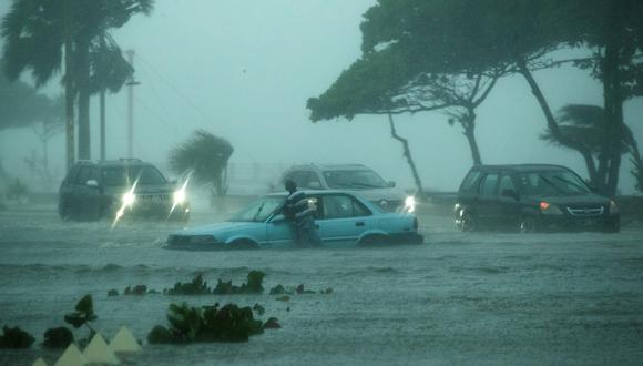 Vehículos circulan bajo la intensa lluvia durante el paso de la tormenta tropical Fred por Santo Domingo, República Dominicana. (EFE/ Orlando Barría).