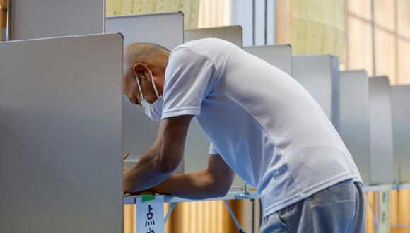 Un votante se prepara para emitir su voto en la elección de la cámara alta en un colegio electoral en Tokio, Japón.