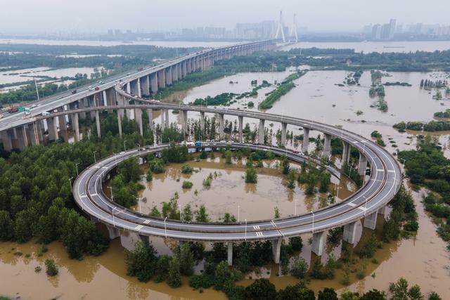 Esta vista aérea muestra un puente que conduce a la inundada isla de Tianxingzhou, que se convertirá en una zona de flujo de inundación para aliviar la presión del alto nivel de agua en el río Yangtze, en Wuhan. (Foto: STR / AFP)