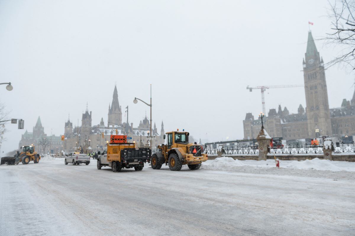 Police and city employees clean up Wellington Street across from Parliament Hill, formerly occupied by the Freedom Convoy, in Ottawa.  (Andrej Ivanov / AFP).