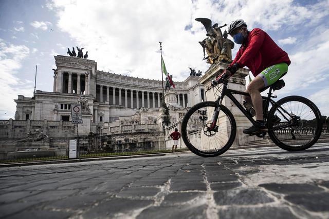 Un ciclista pasa frente al Altare della Patria durante la fase dos del desconfinamiento por el Coronavirus
en Roma, Italia. (EFE / EPA / ANGELO CARCONI).